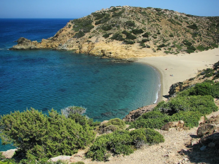 a wide expanse of blue water with a lone beach