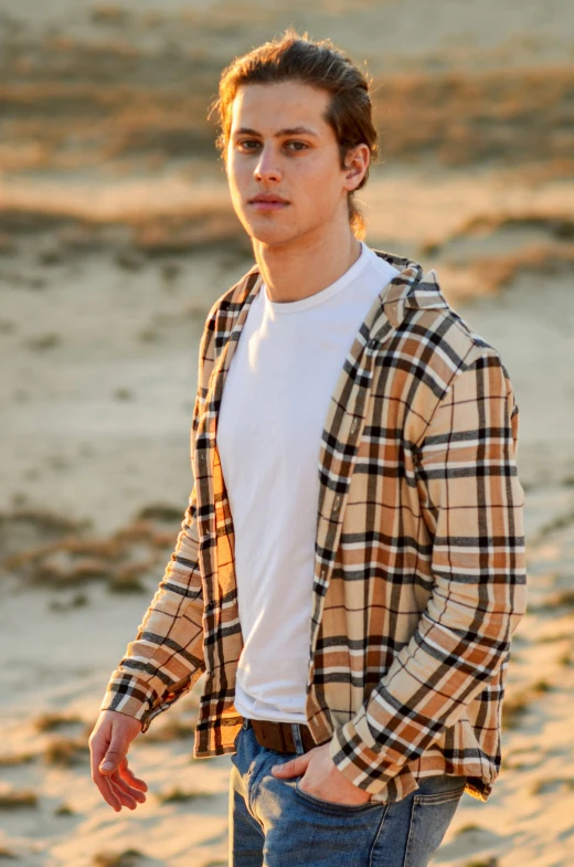 a young man is walking on the beach