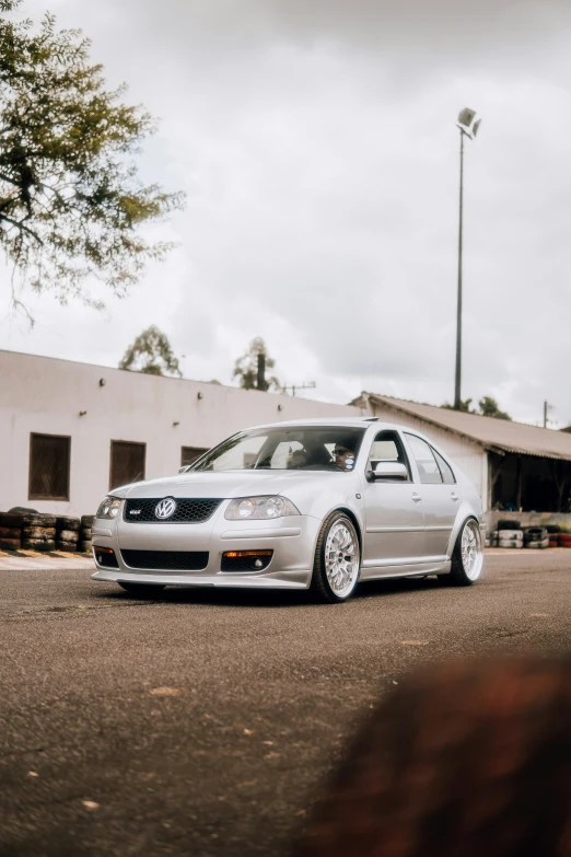 a silver car parked in a parking lot next to a building