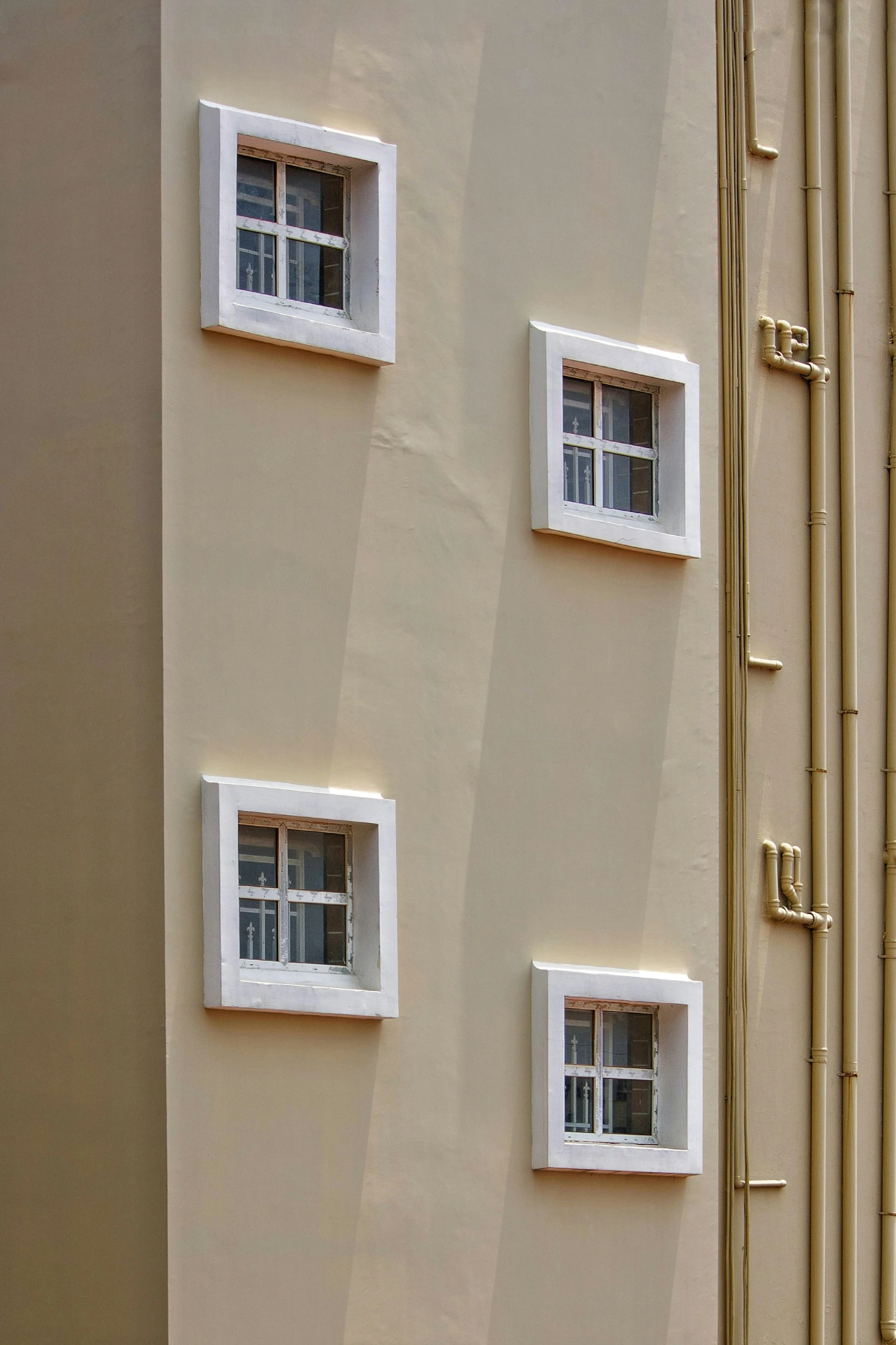 four square windows set into a stucco wall