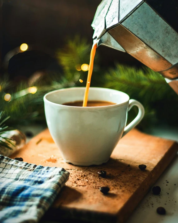 a white cup filled with coffee being poured into it