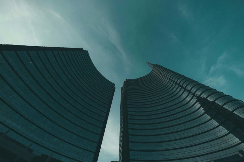 two tall buildings with a blue sky in the background