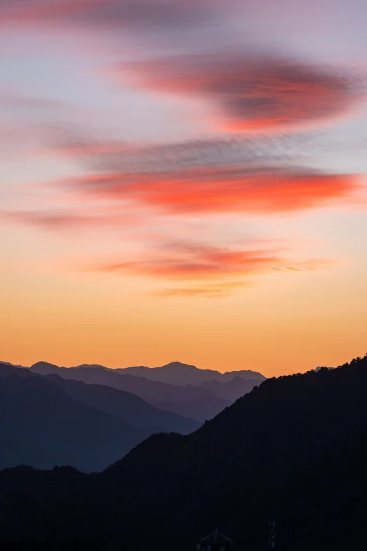 sunset with mountain range in background near town