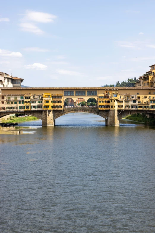 a view of a large bridge spanning the water and buildings in the background