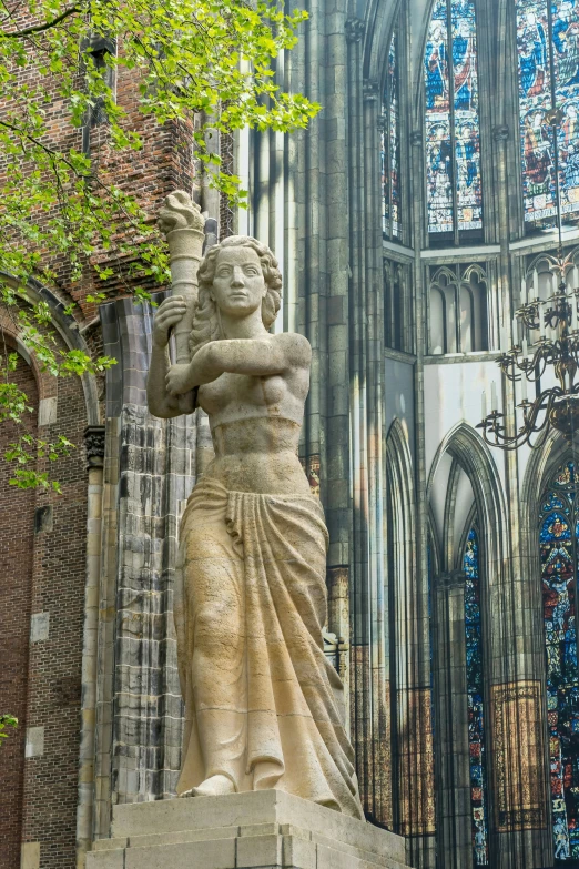 large stone statue standing next to a tall building