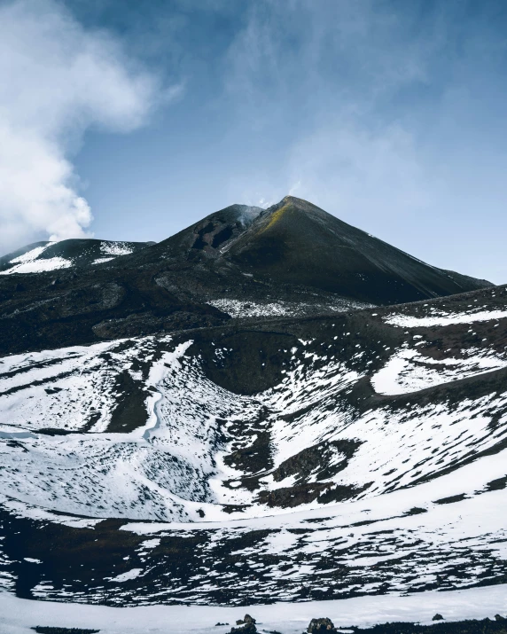 a snow covered mountain with mountains around it