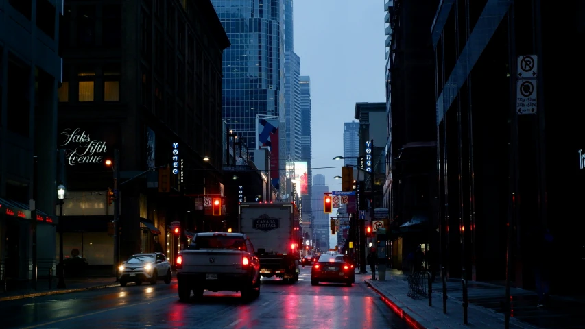 a wet city street is pictured at night in the rain