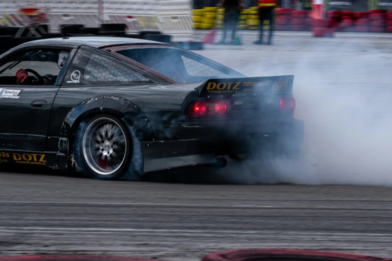 a drift car with smoke pouring out of its exhaust