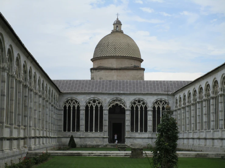 a large courtyard with an arched window and a clock tower