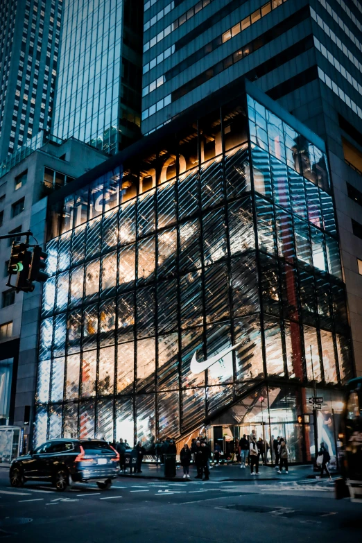 people on the street in front of a glass building