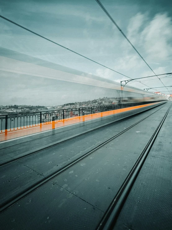 an orange and white train traveling down tracks