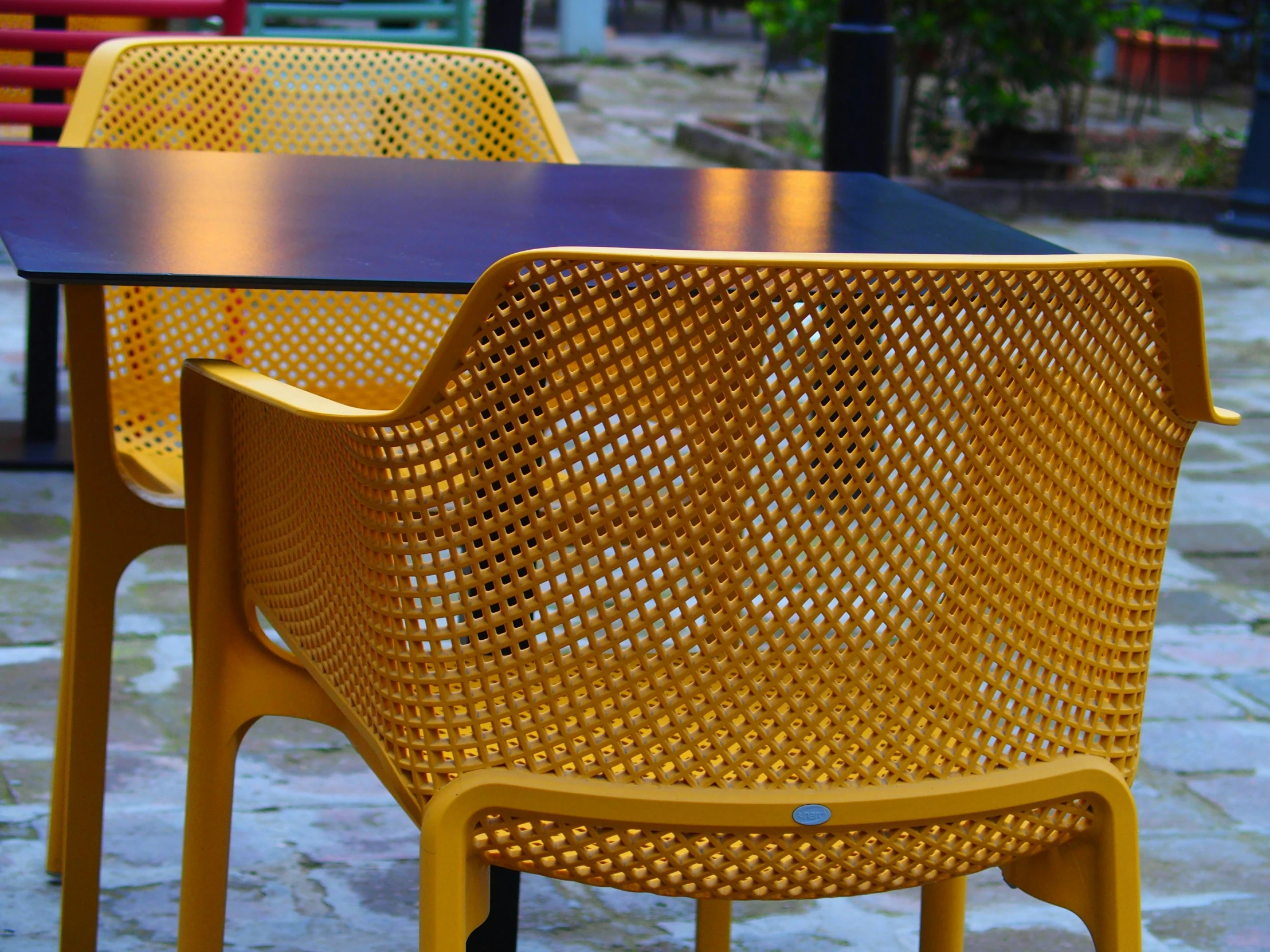 the table is made from two types of different colored plastic chairs