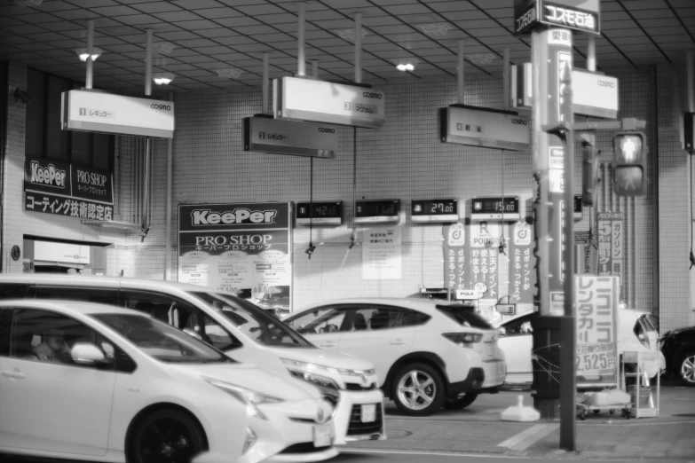 black and white image of city street with several cars in the area