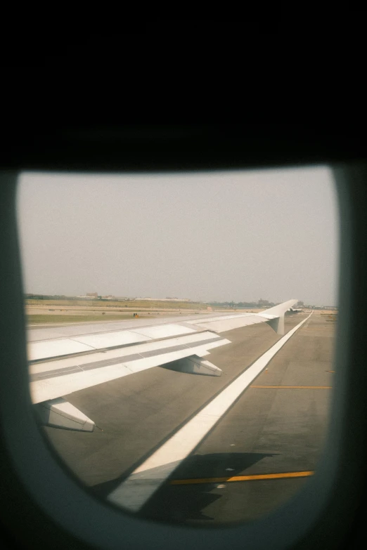 an air plane window looking out at a runway