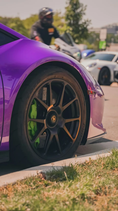 a purple car parked in front of a man