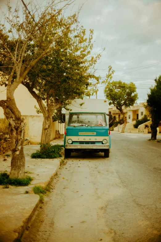 the small blue bus drives down the city street