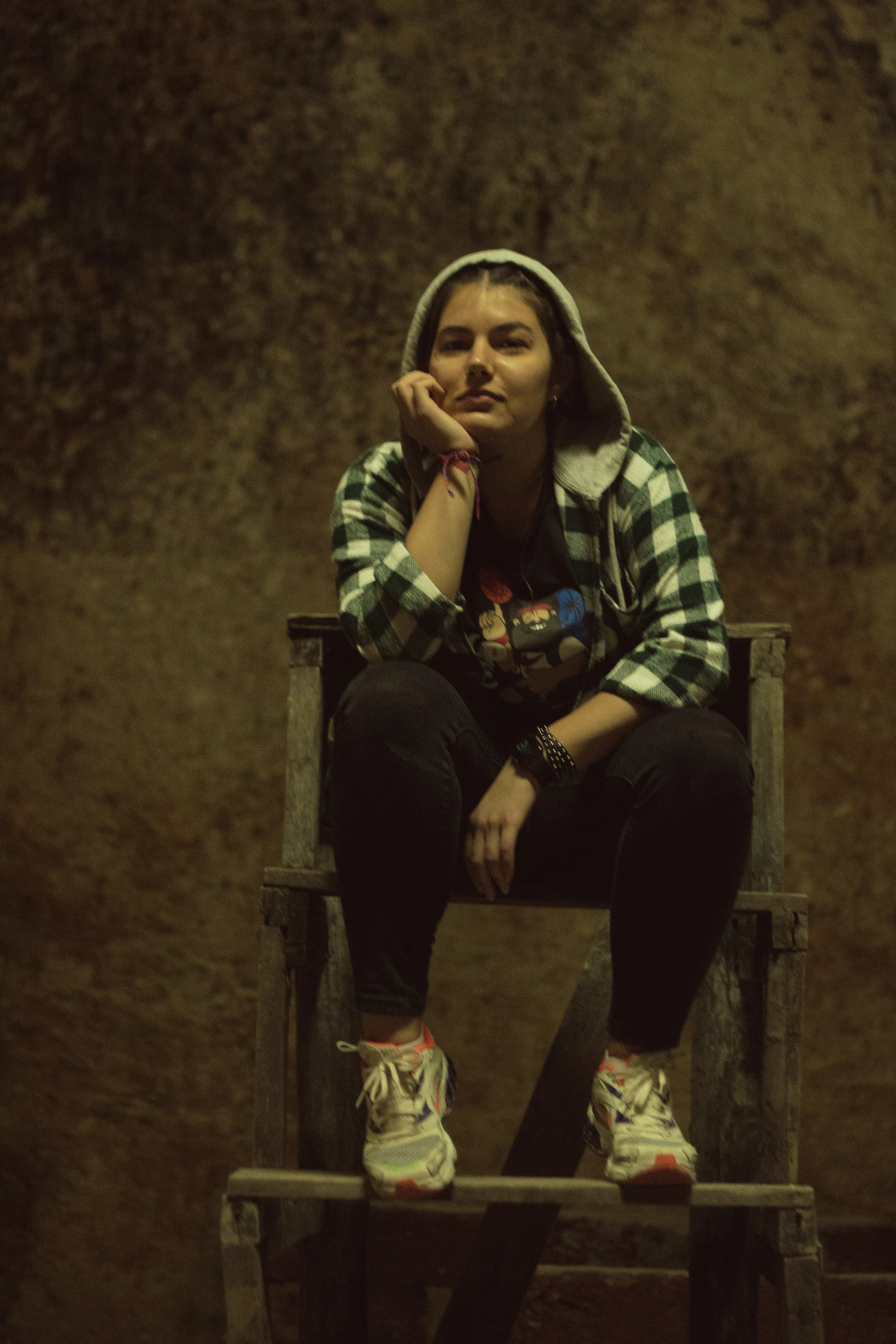 a woman with headphones and checkered shirt sitting in a chair