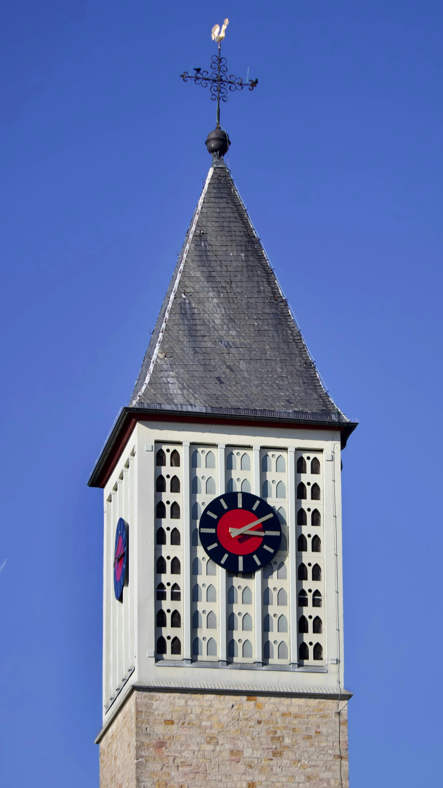 a clock on a brick tower with a weather vane