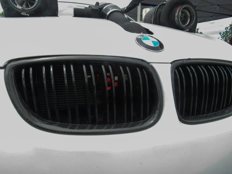 close up of the front grills and hood of a white bmw vehicle