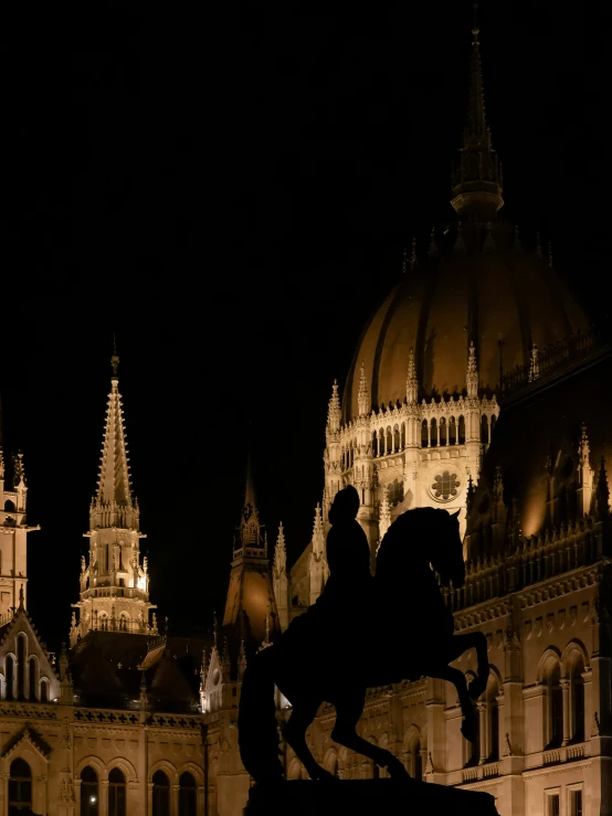 a horse and rider statue standing next to some building