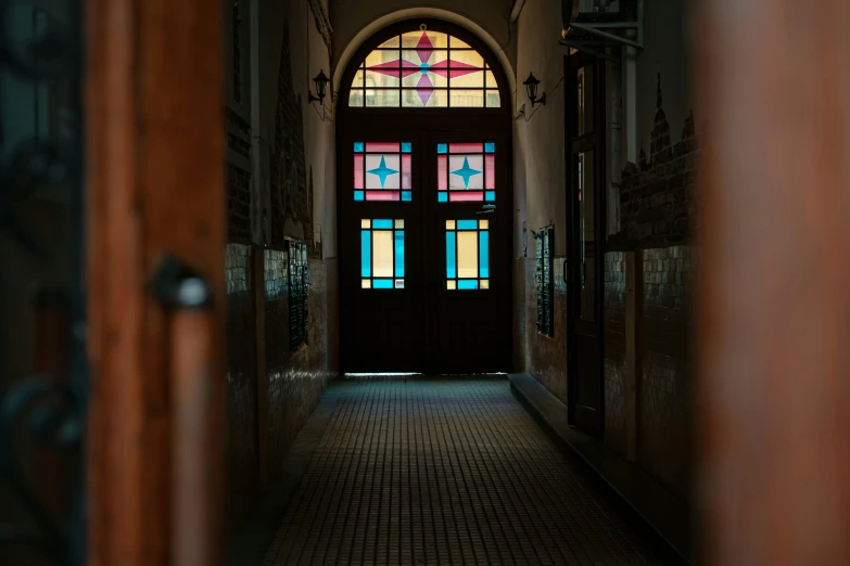 a hallway with a large stain glass window and brick floor