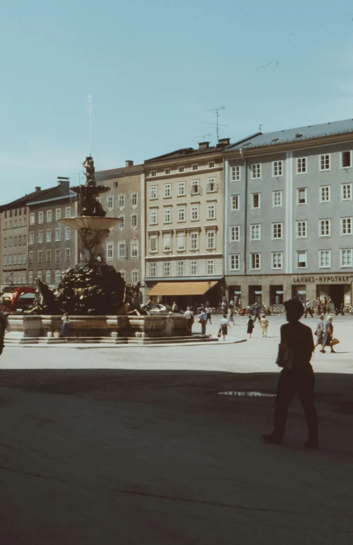 an older building has a water fountain on the street