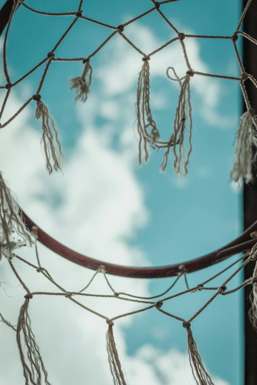 an old net is hanging near a pole and a blue sky