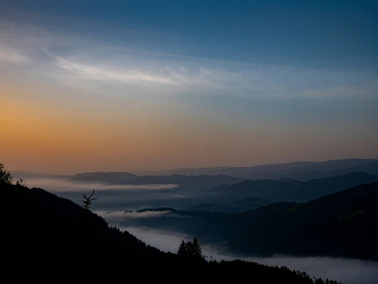 a view of mountains and clouds at sunset