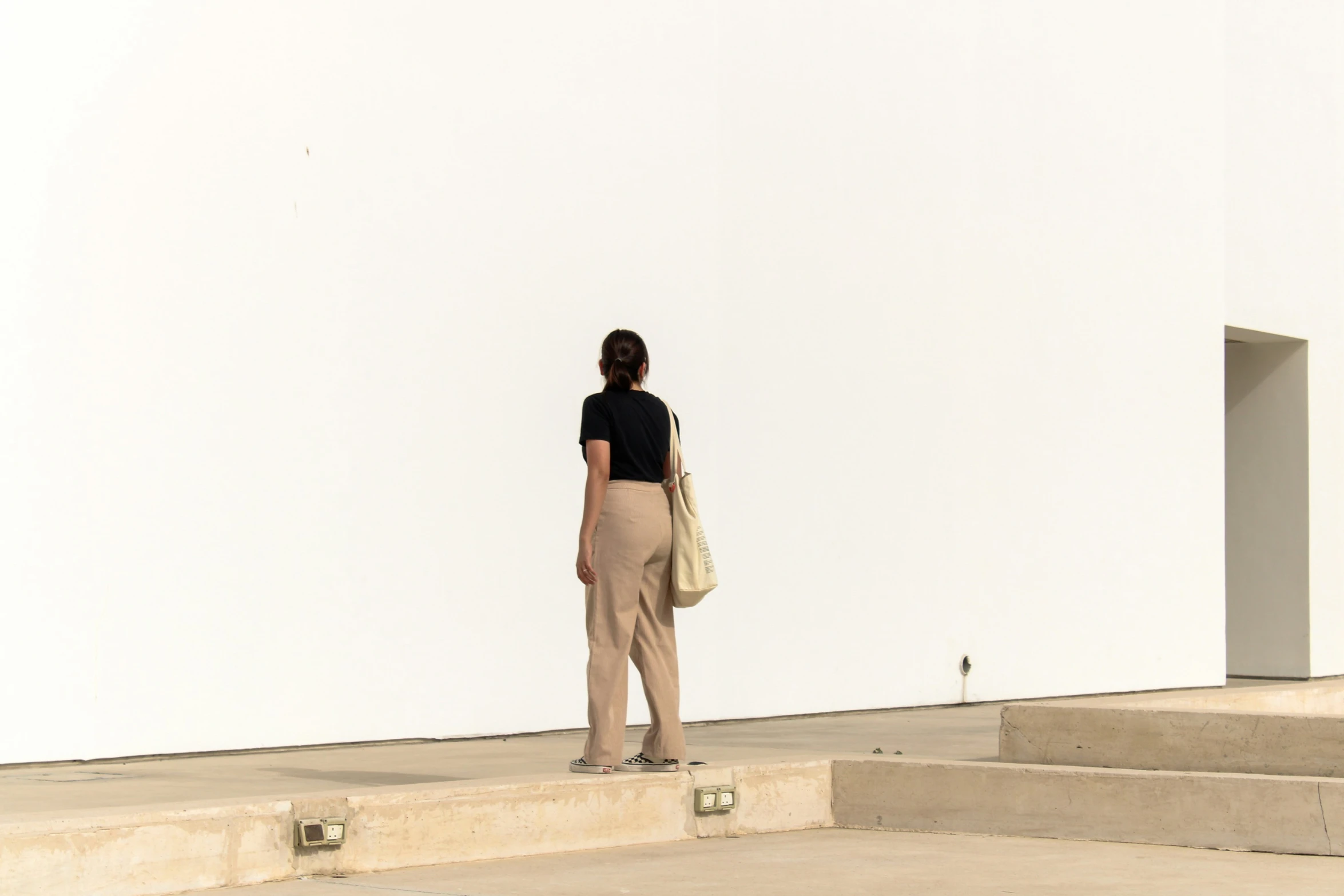 woman with handbag standing at top of stone steps