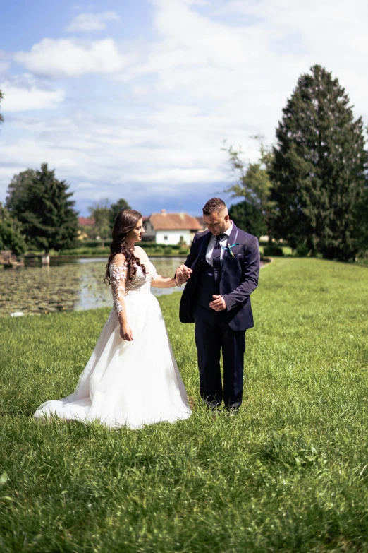 a bride and groom standing on the grass at their wedding