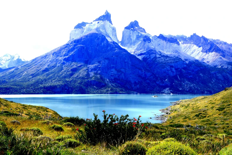 the mountains near the lake are covered in snow