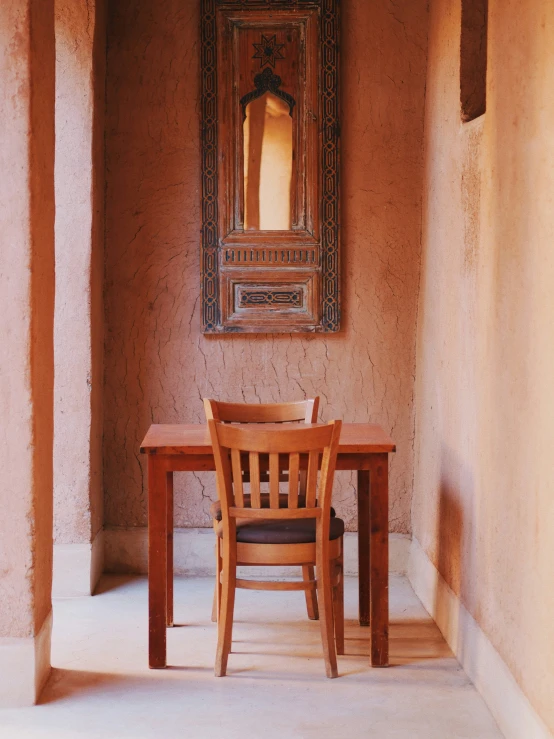 an old room with a wooden dining table and wooden chairs