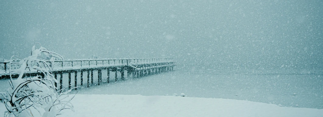 a boardwalk that is covered in snow on a snowy day