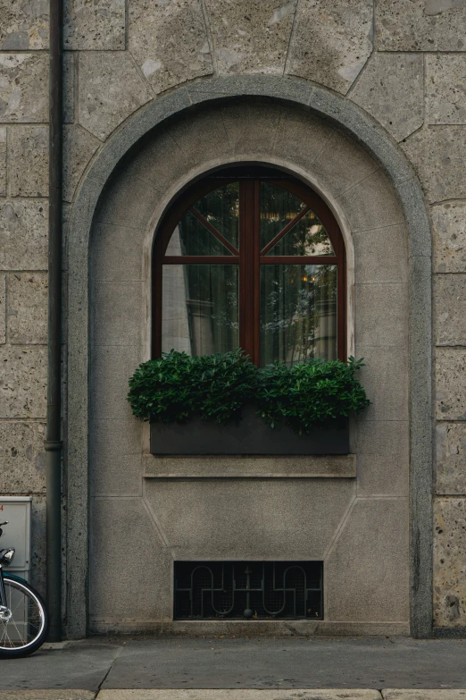 a bicycle sitting next to a window with a window box