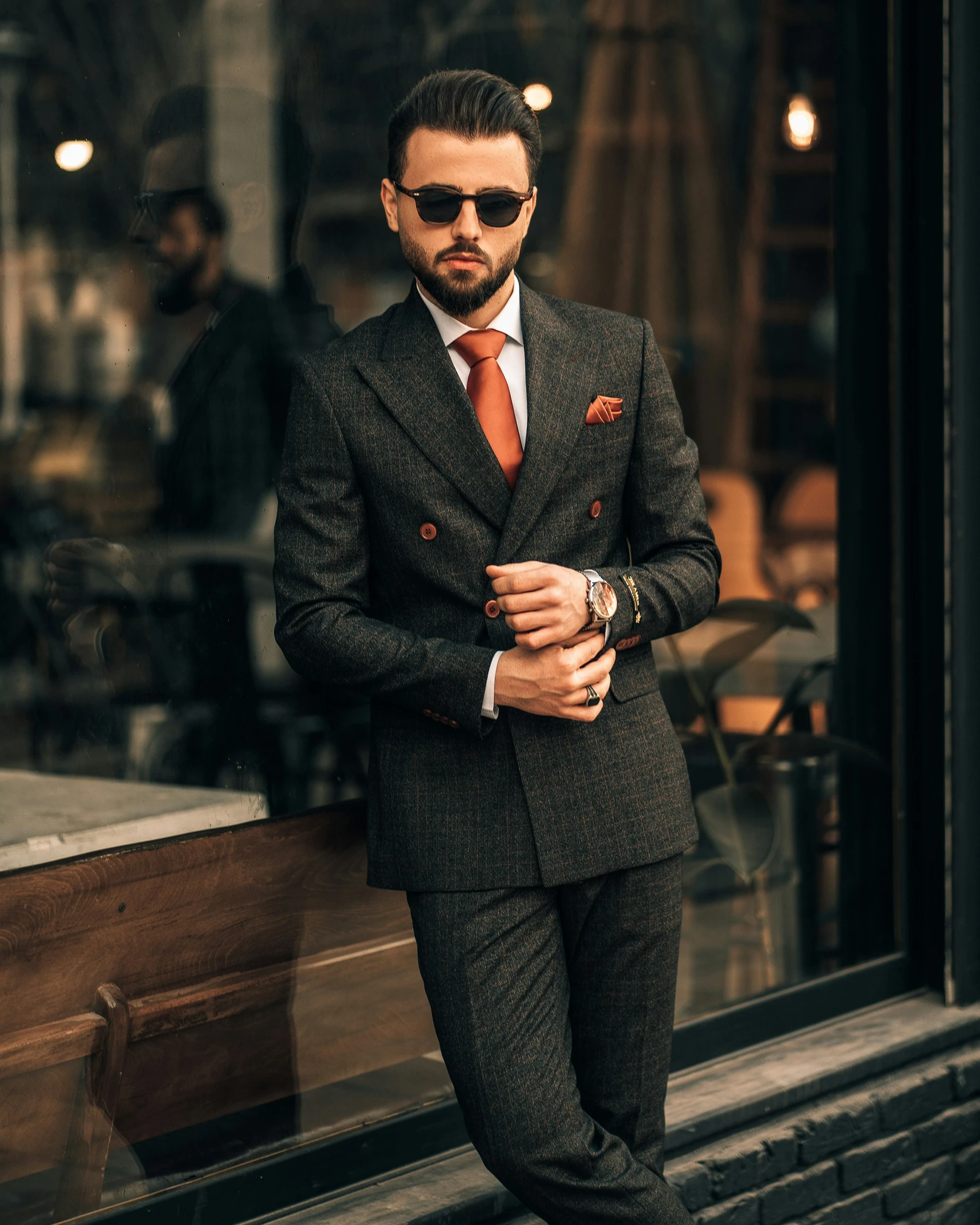 man wearing a suit and tie standing in front of a shop