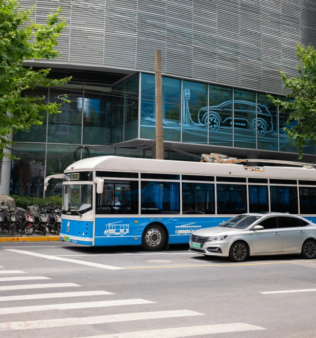 a blue passenger bus driving down a street