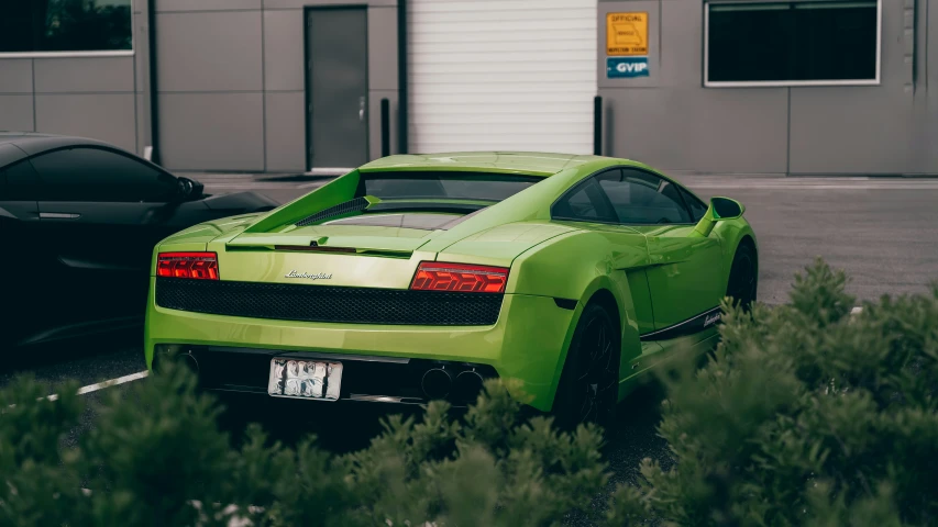 the back end of a lime green sport car in the parking lot