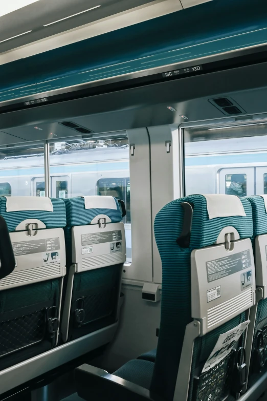 empty seats sit in an airplane with a blue ceiling