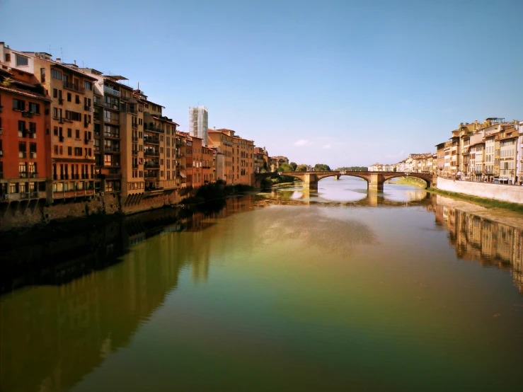 a river is running between tall buildings and bridges