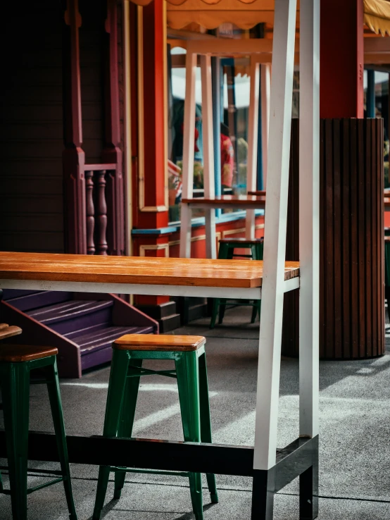 three empty stools sitting in front of an outdoor picnic table