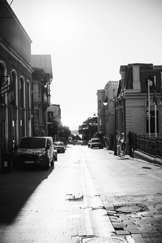 a city street is shown with a fence and cars