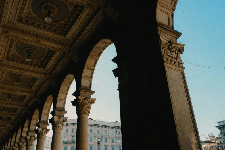 an arch and some blue buildings in the distance