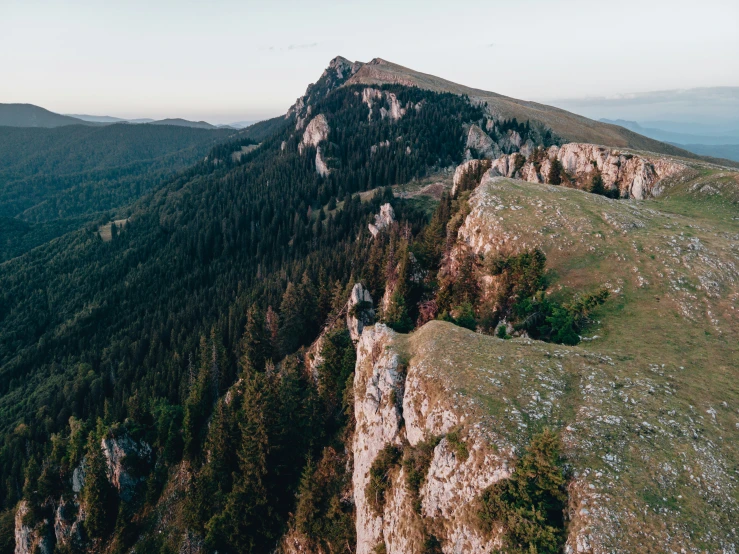 a lone person is standing on top of a rocky mountain