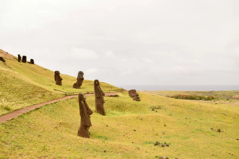 a grassy hill with some stone figures on it