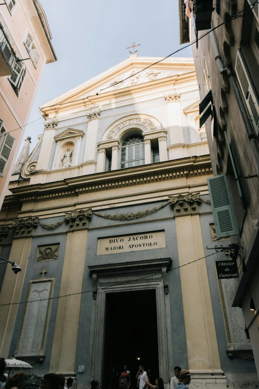 the front entrance to a large building, with a few people walking outside