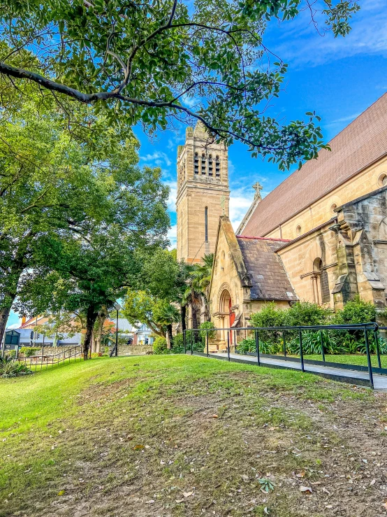 a church with many windows near trees and grass