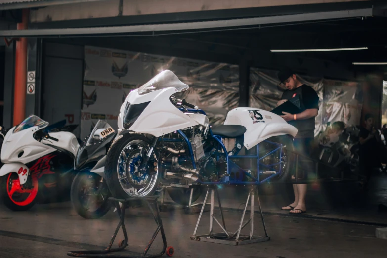 a man looks at three different motorcycles in a building