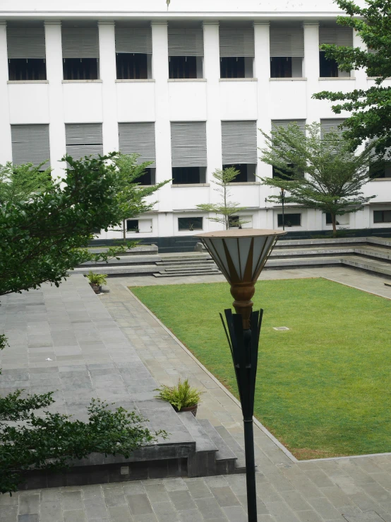 a building is behind a large grassy area in a courtyard