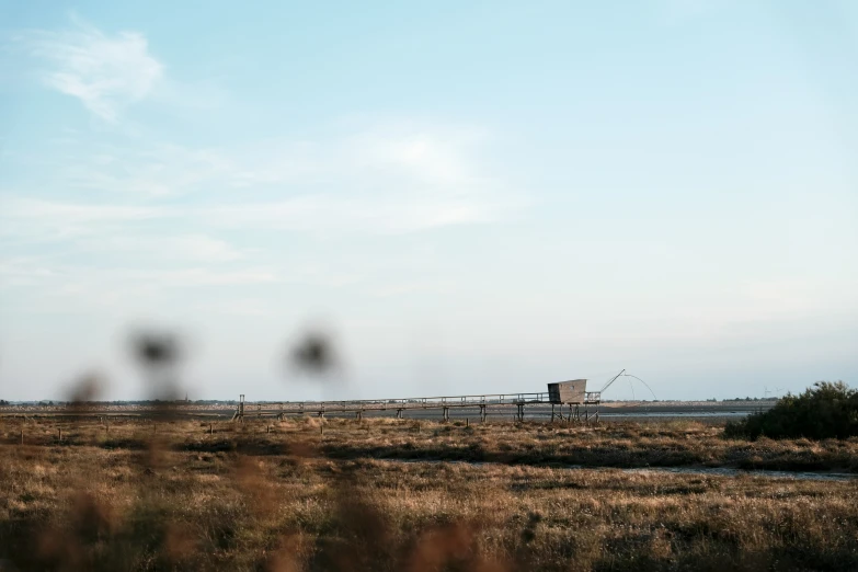 a tractor trailer sitting on top of a dry grass field