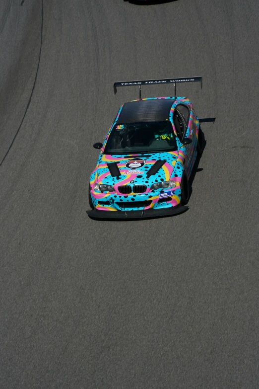 the colorful car is in a turn on the race track